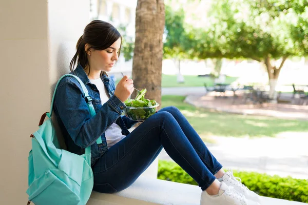 女子学生は授業の合間に健康的な昼食を食べている 若い女性が休みを取って大学でサラダを食べる — ストック写真
