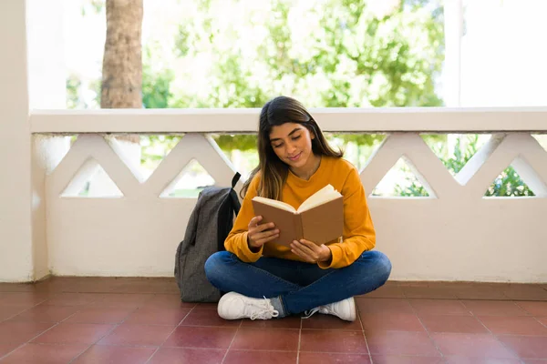 Sırt Çantalı Güzel Mutlu Bir Kadın Öğrenci Koridorda Otururken Kitap — Stok fotoğraf