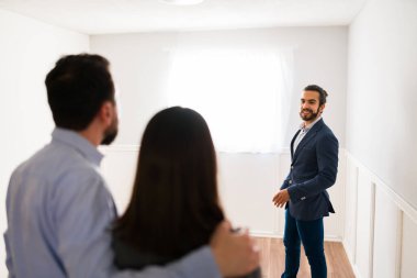 Burası hayallerimizdeki ev. Mutlu bir emlakçıyla turne sırasında kucaklaşan bir çiftin arka görüntüsü.