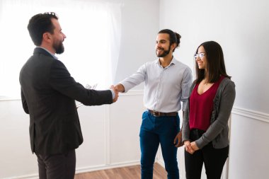 Tanıştığıma memnun oldum. Neşeli genç adam ve karısı mutlu bir emlakçıyla yeni bir ev almak için anlaşma yapıyorlar. 