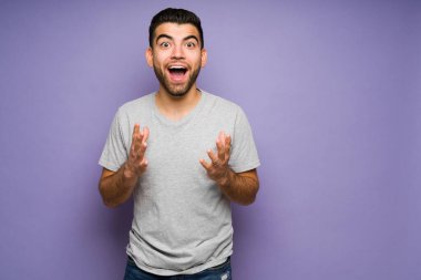 Wow, that is amazing! Cheerful young man looking surprised and excited after receiving good news 