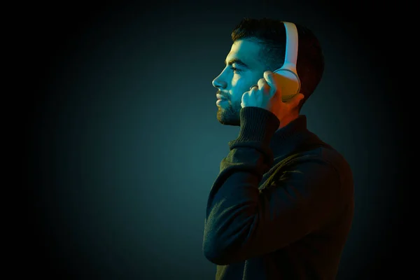 Handsome Latin Man Putting Wireless Headphones Listening Relaxing Music Dark — Fotografia de Stock