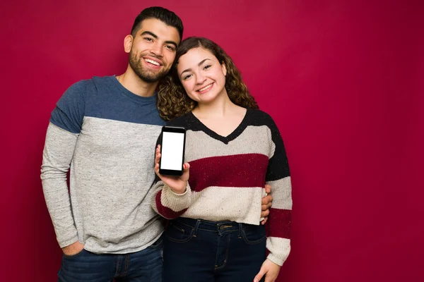 Portrait Multiracial Young Couple Hugging Smiling While Showing Smartphone Screen — Stock Photo, Image