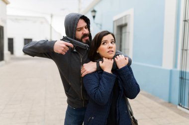 Bağırma! Kızgın suçlu bir adam bir kadının kafasına silah dayadı ve ödül istemek için onu sokakta kaçırdı.