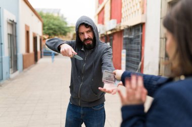 Saldırgan Latin adam genç bir kadını soyarken sokakta bıçakla tehdit etmiş.