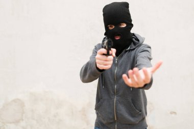 Sokaktaki birinden çalarken siyah kar maskesi takan bir suçlunun portresi. Kar maskeli bir hırsız silah zoruyla soygun yapıyor.