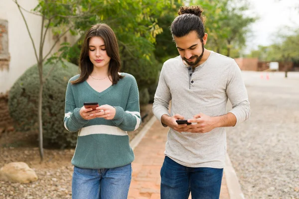 Couple Détendu Utilisant Les Médias Sociaux Textos Sur Leurs Smartphones — Photo