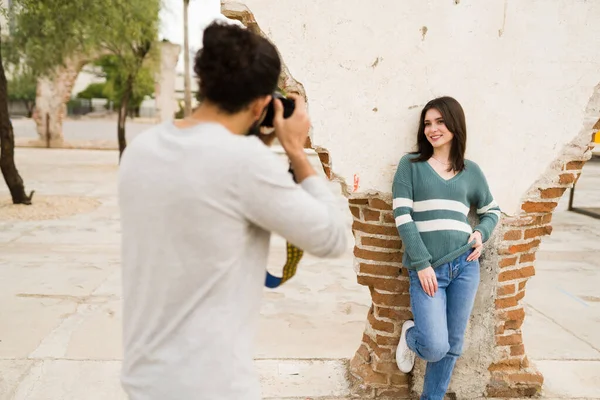 迷人的年轻女子摆姿势为她的男朋友拍照 一个摄影师给他的女朋友拍照的后视镜 — 图库照片