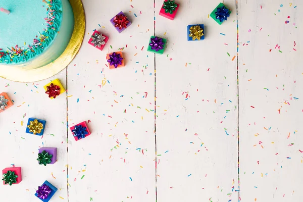 在一个美味的蛋糕旁边 摆放着许多小的生日礼物 上面撒满了糖果 用来庆祝一个派对 — 图库照片
