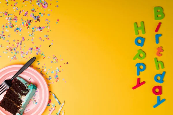 Płaskie Ułożenie Kolorowego Znaku Urodzinowego Kawałkiem Ciasta Czekoladowego Konfetti Okazji — Zdjęcie stockowe