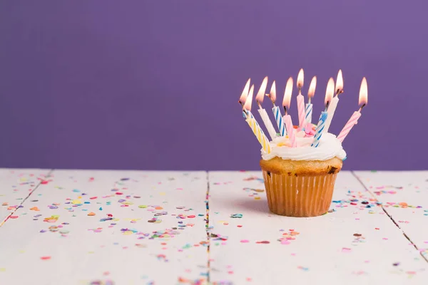 Mange Tændte Stearinlys Lille Lækker Cupcake Træbord Med Farverig Konfetti - Stock-foto