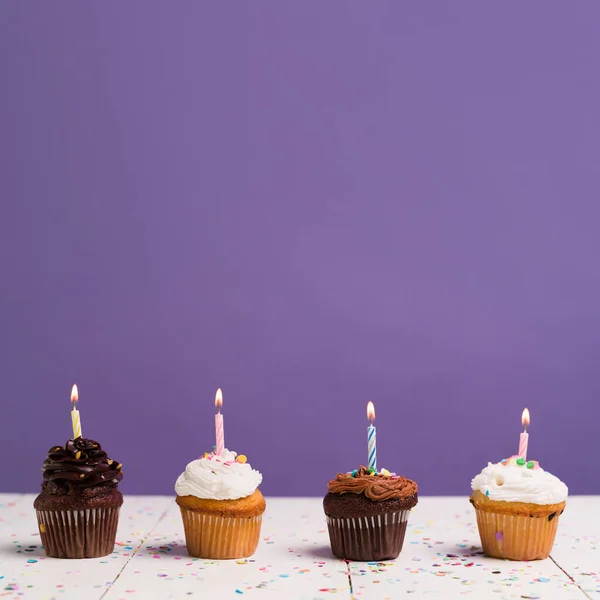 Chokolade Vanilje Cupcakes Med Tændte Stearinlys Til Fødselsdagsfest Foran Lilla - Stock-foto