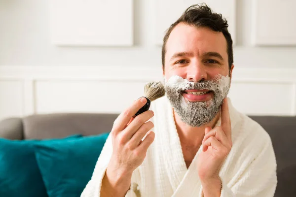 我准备刮胡子了一个快乐的男人一边笑着一边用白霜泡沫刮胡子 — 图库照片