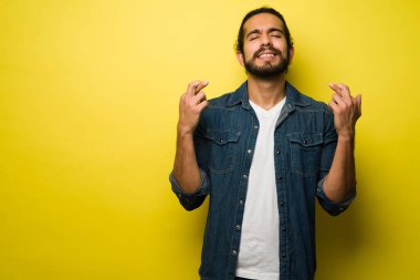 Lütfen. Umut dolu bir adam şans diliyor ve dilekleri gerçekleşsin diye dua ediyor.