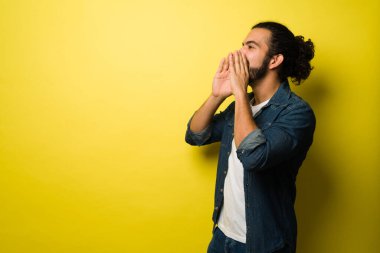 Kopya alanının yanında bağıran ve yüksek sesle mesaj veren Latin bir gencin profili