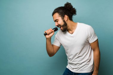 Karaokeyle eğleniyorum. Amatör şarkıcı mikrofonla şarkı söylüyor ve heyecanlanıyor. 