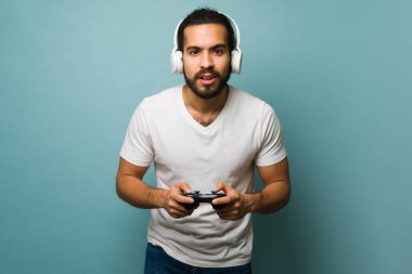 Eğlenceli bir video oyunu oynarken kulaklık ve oyun sahası kullanan 20 'li yaşlarında bir adam. 