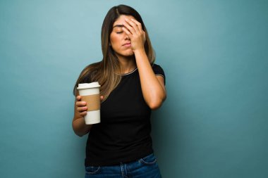 Henüz çalışamıyorum. Yorgun genç bir kadın sabahları kahve içerek kendini yorgun hissediyor.