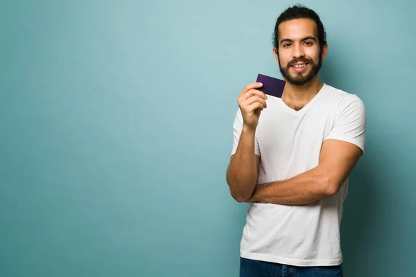 ヒスパニック系の若い男は彼の新しいクレジットカードで支払い後非常に幸せ感じます — ストック写真
