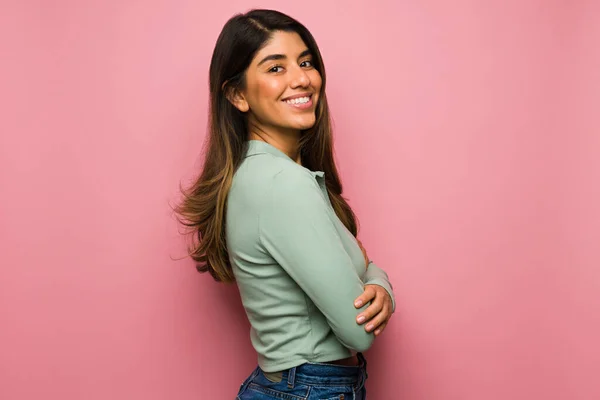 明るいピンクの背景の前で幸せを感じる魅力的なヒスパニック系の女性の側面図 — ストック写真