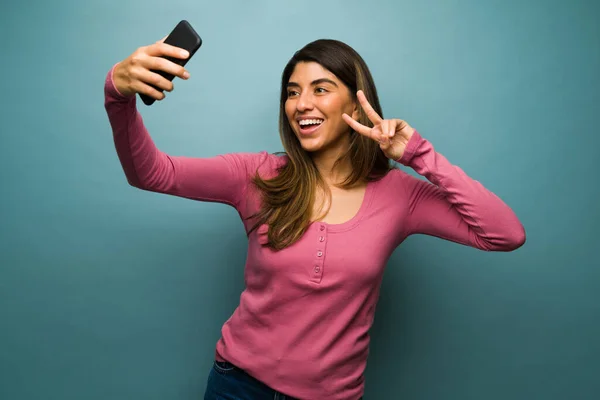 Atraktivní Mladá Žena Dělat Mírové Znamení Brát Selfie Svým Telefonem — Stock fotografie