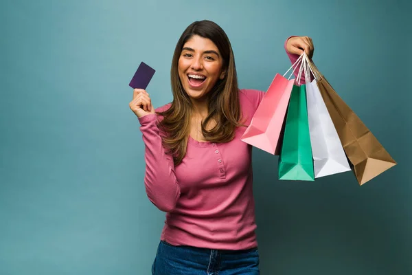 カラフルなショッピングバッグを持ち モールでクレジットカードで支払う興奮した女性の肖像画 — ストック写真