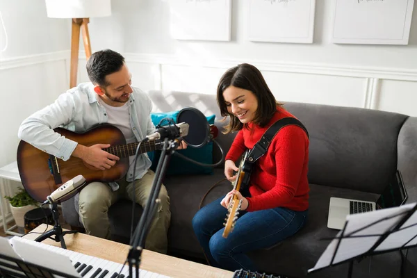 ギターを弾きながら楽しそうに笑っている女性 新しい曲をリハーサルしながらバンドでアコースティックギターを弾いている幸せなラテン人 — ストック写真