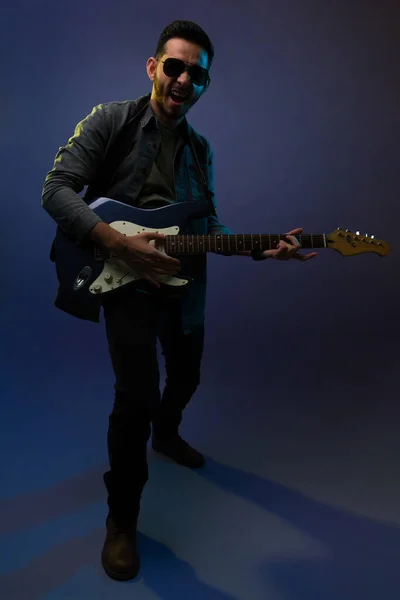 ロックコンサートの前にエレキギターを演奏するサングラスと流行の衣装を持つ才能のあるヒスパニック男 — ストック写真