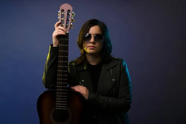 Sério Atraente Mulher Guitarrista Posando Com Uma Guitarra Acústica Contra — Fotografia de Stock