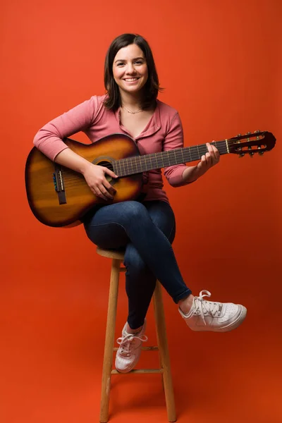 Linda Mulher Caucasiana Sentada Banquinho Aprendendo Tocar Guitarra Acústica Contra — Fotografia de Stock