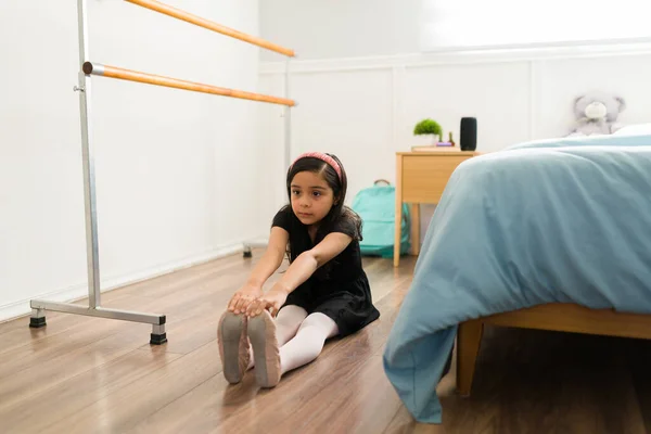 Elementarna Dziewczyna Leżąca Podłodze Wykonująca Ćwiczenia Rozciągające Przed Rozpoczęciem Praktyki — Zdjęcie stockowe