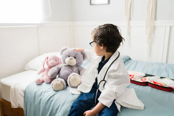 賢い子供は医学を勉強したい 研究室のコートを着てベッドルームで聴診器を使う白人の子供 — ストック写真