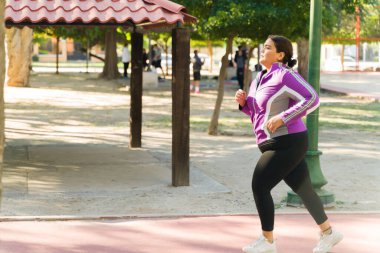 Kilo vermeye çalışan şişman bir kadın. Aktif bir kadının sağlıklı bir yaşam tarzını takip edişinin yan görüntüsü