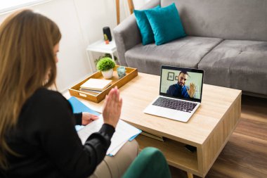 Tanımlanamayan beyaz kadın evdeki sanal avukatına laptoptaki bir video görüşmesinde merhaba diyor.