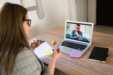 Kadın psikiyatrist, video görüşmesi sırasında depresyondaki bir erkeğe reçeteli ilaç ve antidepresan veriyor.