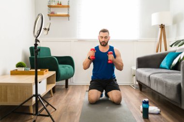 Yakışıklı antrenör canlı yayında spor yapıyor. Sanal koç bir video çalışıyor ve kaydediyor 