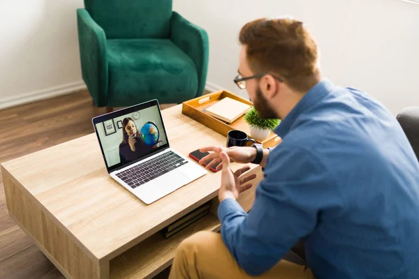 男子在家与女性旅行社进行视频通话以预订旅行或度假的背景图 — 图库照片
