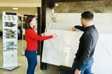 Çekici genç bir çift mağazadaki yeni döşemeleri ya da mutfak tezgahlarını seçiyor.