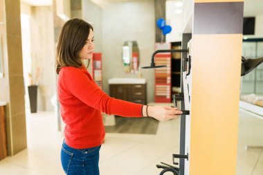 Mağazada yeni duş ve banyo ürünleri seçen beyaz bir kadının yan görüntüsü