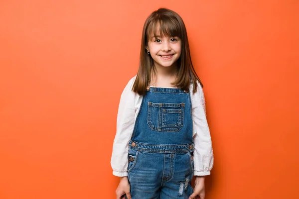 Piękna Brunetka Dziewczynka Uśmiecha Się Studio Pomarańczowym Tle — Zdjęcie stockowe