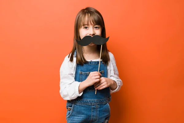 Rolig Liten Flicka Spelar Och Håller Papper Mustasch Över Munnen — Stockfoto