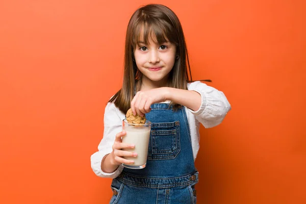 一个可爱的小女孩享受一杯牛奶和巧克力饼干的肖像 — 图库照片