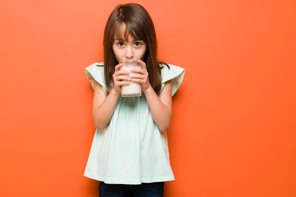 白人女孩穿着休闲装 在工作室里喝着杯子里的牛奶 — 图库照片