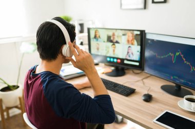 Ev işi yaparken iş arkadaşlarıyla yaptığı bir video görüşmesinde kulaklık takan yüzüncü yıl adamı. Finans işinden bahsediyorum.