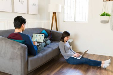 Kripto para birimini öğrenirken evde finans sektöründe çalışan mutlu genç çift.