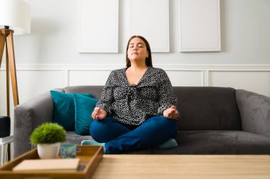 Endişe için meditasyon. Güzel, rahat kadın daha az stresli hissetmek için meditasyon yaparken nefes egzersizleri yapıyor.
