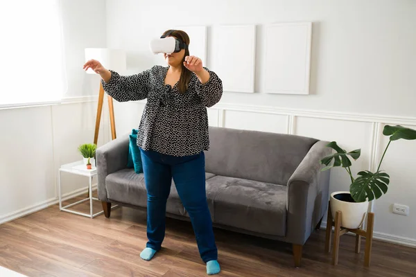 在家里用Vr眼镜的西班牙胖女人玩得很开心 额外尺寸的年轻女子玩虚拟现实电子游戏 — 图库照片