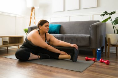 Mutlu genç bir kadın evde çalışmaya başlamadan önce ısınma egzersizleri yapıyor. 