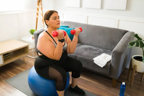 减肥的目标 有自信的超重女人在做普拉提时举起哑铃重量 — 图库照片