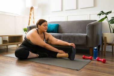 Mutlu genç bir kadın evde çalışmaya başlamadan önce ısınma egzersizleri yapıyor. 